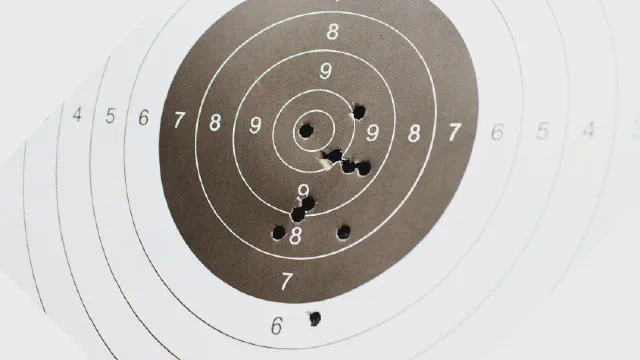 A scoring target with a tight group of shots clustered around the centre rings