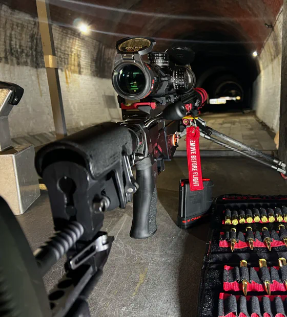 A scoped target rifle set up on the firing point at Phoenix Rifle Club, looking down the tunnel range